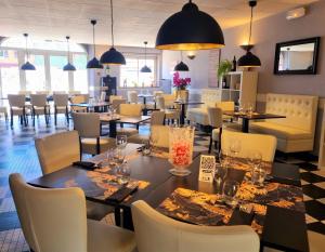 un restaurante con mesas y sillas en una habitación en Hôtel Restaurant du Commerce, en Estang