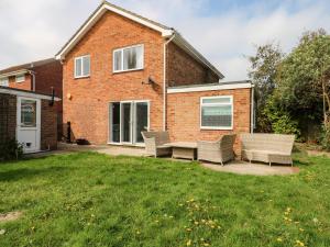 a brick house with chairs and a patio at Alverstone Seaside in Gosport