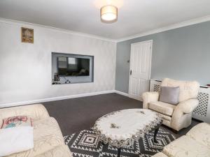 sala de estar con sofá, 2 sillas y mesa en Alverstone Seaside en Gosport