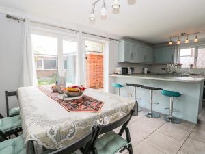 a kitchen with a table with a bowl of fruit on it at Alverstone Seaside in Gosport