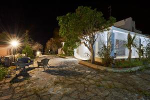 a patio at night with a table and a tree at Villa Luminosa in Brindisi
