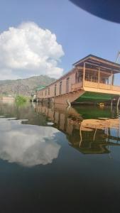 un reflejo de un edificio en un cuerpo de agua en Houseboat Pride of India, en Srinagar