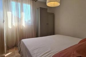 a bedroom with a white bed and a window at L'Elementariu in Nonza