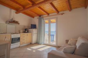 a kitchen with a couch and a kitchen with a balcony at Villa Theodora View Apartments Erato in Agios Georgios Pagon
