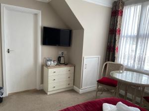 a bedroom with a dresser and a tv on the wall at The Sandrock in Clacton-on-Sea
