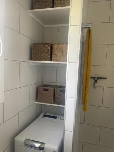 łazienka z toaletą i koszami na półkach w obiekcie 2 Bedroom Apartment , Son Bou w Son Bou