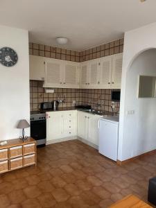 kuchnia z białymi szafkami i czarnymi urządzeniami w obiekcie 2 Bedroom Apartment , Son Bou w Son Bou