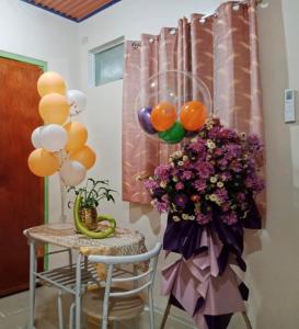 un tavolo con un mucchio di palloncini e un mazzo di fiori di Ianka & Enio Dream Suites a Digos