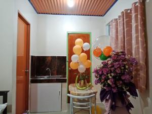 een kamer met een tafel met ballonnen en bloemen bij Ianka & Enio Dream Suites in Digos