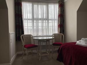 a room with a table and chairs and a window at The Sandrock in Clacton-on-Sea