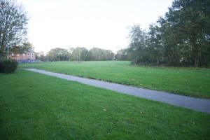 een wandelpad in een park met een groen veld bij 2ndHomeStays -Willenhall-Charming 3-Bedroom Home in Walsall