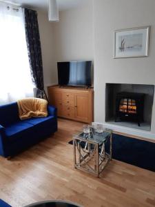 a living room with a blue couch and a fireplace at Charming Mid Terrace Cottage in Conwy