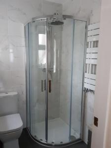 a glass shower in a bathroom with a toilet at Charming Mid Terrace Cottage in Conwy