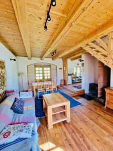 a large living room with wooden ceilings and a table at Cisowe Wzgórze in Rowele