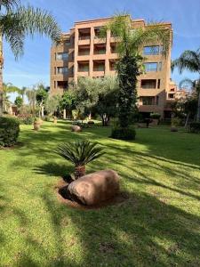 een grote rots in het gras voor een gebouw bij APPARTEMENT MARRAKECH HIVERNAGE in Marrakesh