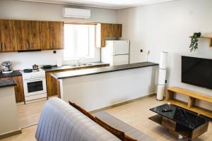 salon z kanapą i kuchnią w obiekcie Southplace63 Cozy house 500m From beach w mieście Vari