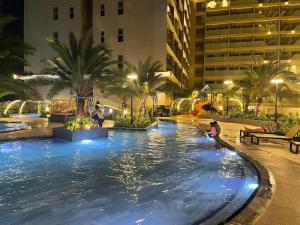 a large swimming pool in a hotel at night at The sóng Remy Apartment in Vung Tau