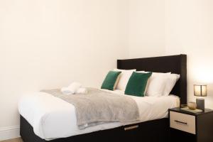 a bedroom with a large bed with green and white pillows at Apartment 4 - Beautiful 1 Bedroom Apartment Near Manchester in Worsley