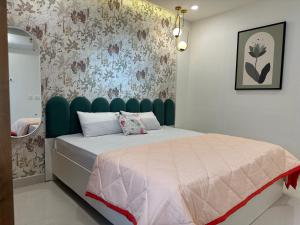 a bedroom with a bed with a green headboard at Autumn suites in Hyderabad