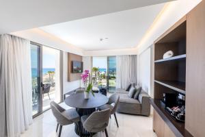 a living room with a table and chairs and a couch at Pavlo Napa Beach Hotel in Ayia Napa