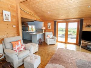 a living room with two chairs and a kitchen at Tilly's Lodge in Doncaster
