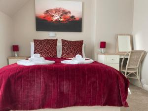 a bedroom with a purple bed with two towels at The Sandrock in Clacton-on-Sea