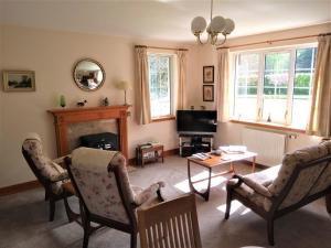 a living room with a fireplace and a tv at Bridge of Bennie Cottage in Banchory