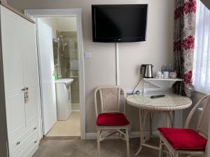 a room with a table and chairs and a television on the wall at The Sandrock in Clacton-on-Sea