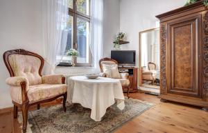 Villa Minheim - FeWo 04 في هيرينجسدورف: غرفة معيشة مع طاولة وكرسيين وتلفزيون