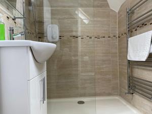a bathroom with a shower with a glass door at The Sandrock in Clacton-on-Sea
