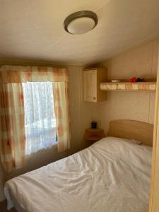 - une petite chambre avec un lit et une fenêtre dans l'établissement The Vacation golden gate towyn, à Kinmel Bay