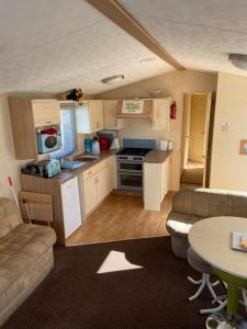 eine kleine Küche und ein Wohnzimmer in einem Wohnwagen in der Unterkunft The Vacation golden gate towyn in Kinmel Bay