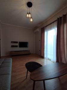 a living room with a table and a television at Mirina center apartments in Myrina