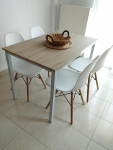a wooden table with white chairs and a bowl on top at Mirina center apartments in Myrina