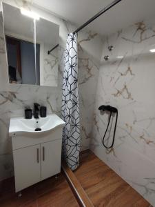 a bathroom with a sink and a shower at Mirina center apartments in Myrina