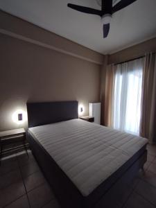 a bedroom with a large bed and a ceiling fan at Mirina center apartments in Myrina