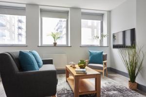 a living room with a couch and a table at Wembley Stadium by Viridian Apartments in London