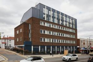 a large brick building with cars parked in front of it at Wembley Stadium by Viridian Apartments in London