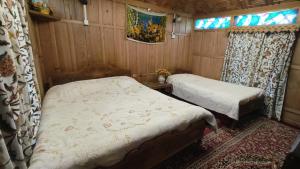 a bedroom with two beds in a wooden room at Houseboat Pride of India in Srinagar