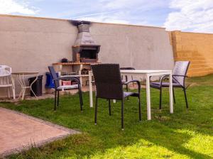 a table and chairs in a yard with an outdoor grill at Cuencaloft Casa Rural Lagunas de Arcas in Arcas