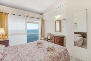 a bedroom with a bed and a view of the ocean at Bahia Dorada 4 in Estepona