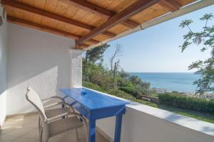 a blue table and chairs on a balcony with the ocean at Villa Theodora View Apartments Erato in Agios Georgios Pagon