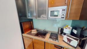 una piccola cucina con lavello e microonde di Villa Parkblick a Rostock