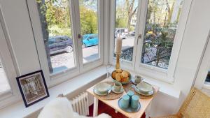a room with windows and a table with a candle at Villa Parkblick in Rostock +3 photos