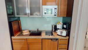 a kitchen counter with a sink and a microwave at Appartement Wachtlerstraße in Rostock