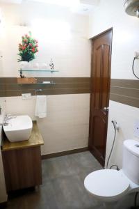a bathroom with a white toilet and a sink at Divine India Service Apartment 3 BHK D-198 Saket in New Delhi