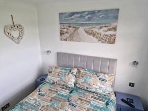 sypialnia z łóżkiem i zdjęciem plaży w obiekcie Burgh Castle w mieście Belton