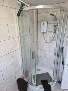 a shower with a glass door in a bathroom at Burgh Castle in Belton