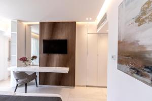 a dining room with a table and a tv on a wall at Pavlo Napa Beach Hotel in Ayia Napa