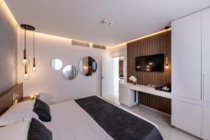 a bedroom with a large bed and a television at Pavlo Napa Beach Hotel in Ayia Napa